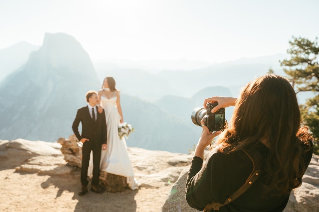 Bride and groom posing for a wedding photographer on a mountain overlook