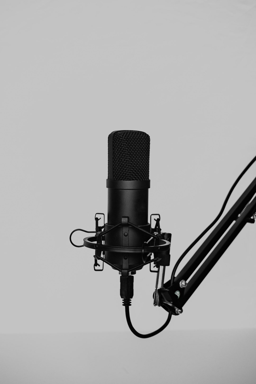 Condenser microphone on a boom arm set up for podcast recording