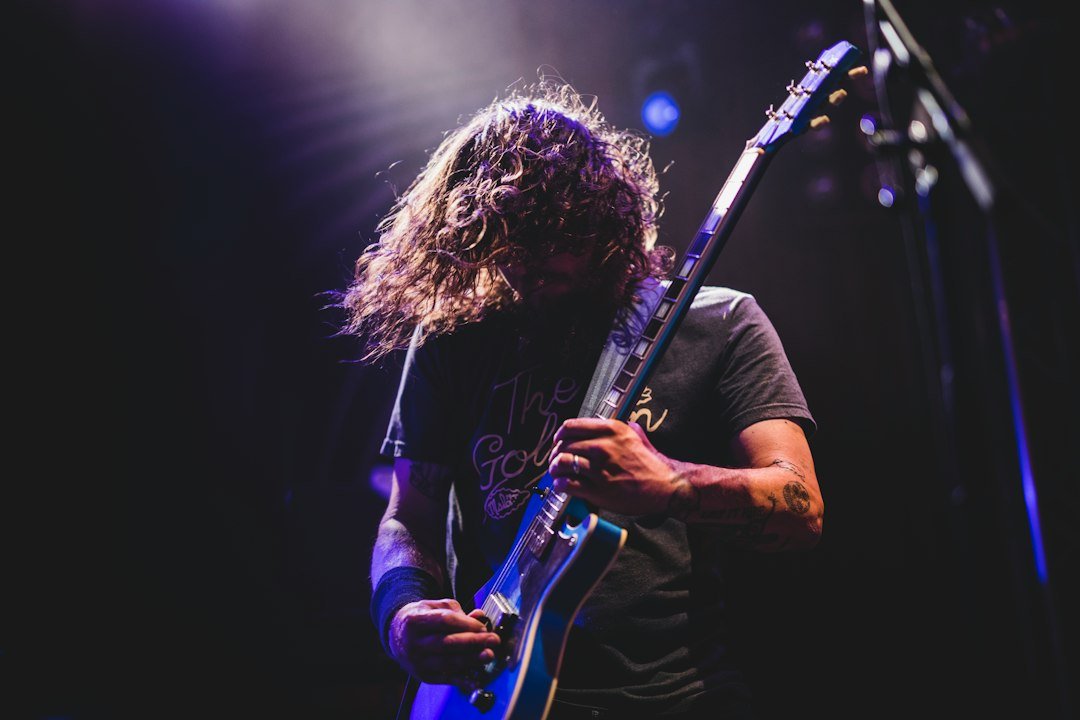Musician playing electric guitar, promoting music on social media