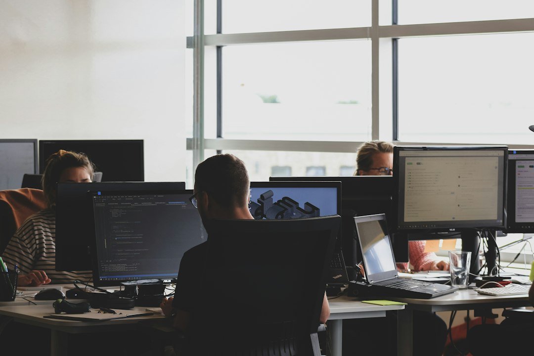 People working at computer monitors, illustrating bulk ordering across multiple client accounts