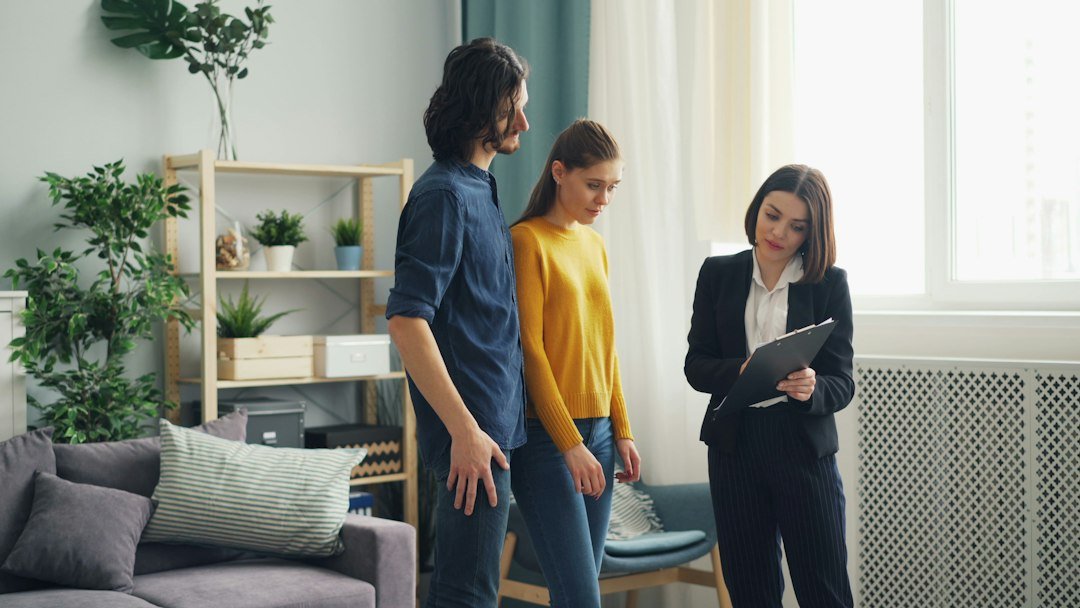 Real estate agent showing a property to clients in a living room