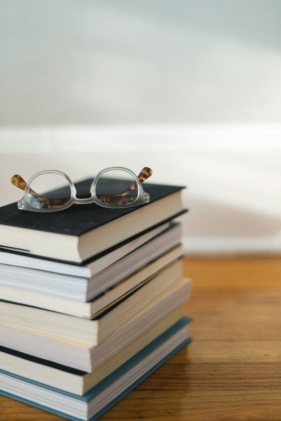 Stack of books with reading glasses on top for a book launch