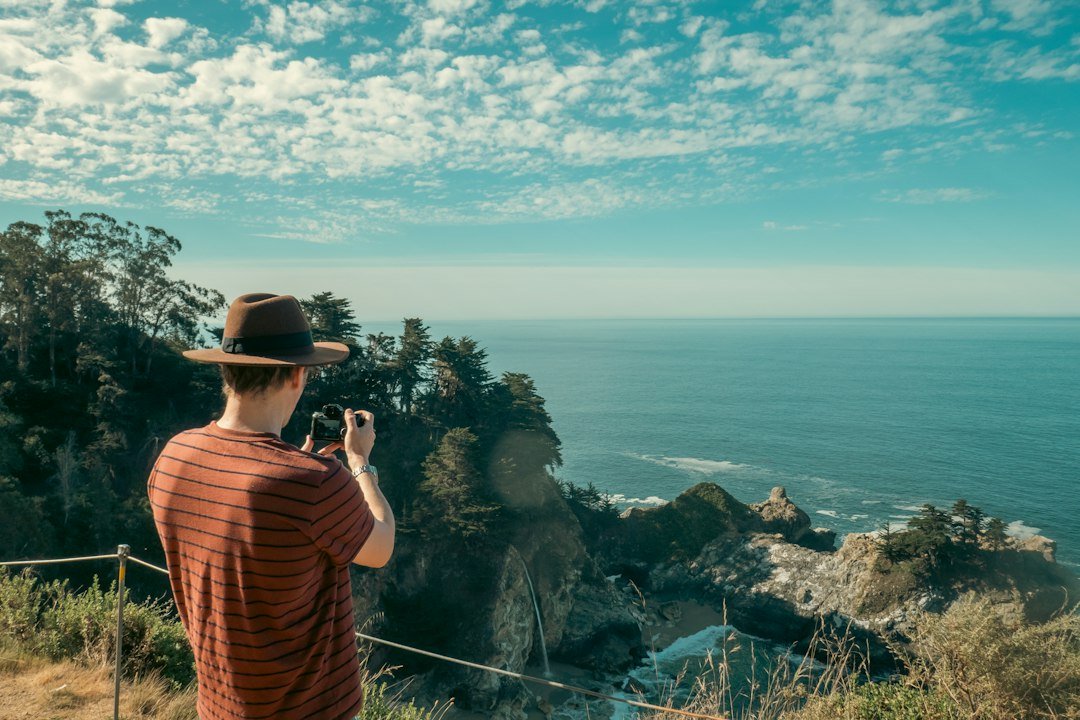 Traveler photographing an ocean view with a smartphone