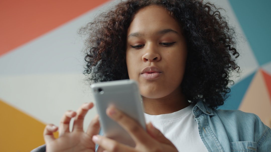Young woman using her smartphone against a colorful background